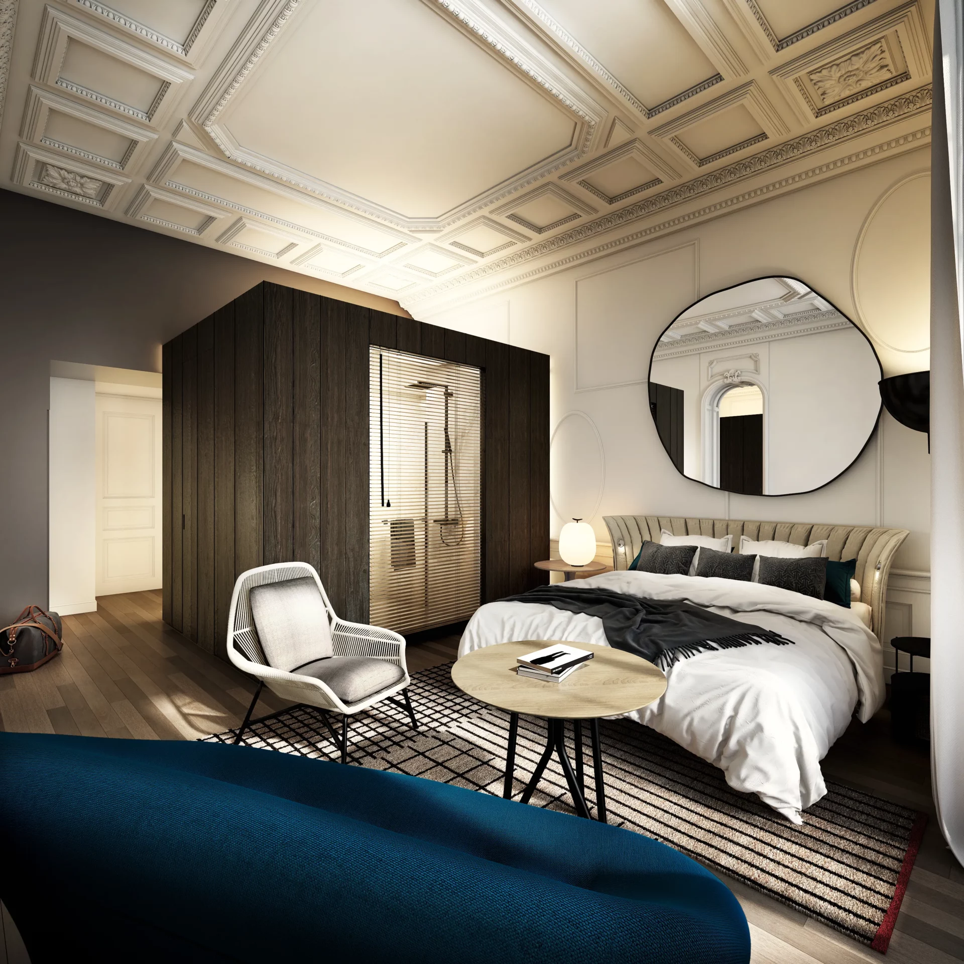 Chambre d’hôtel associant architecture classique, moulures d’origine, mobilier contemporain et salle d’eau intégrée dans un volume central en bois.